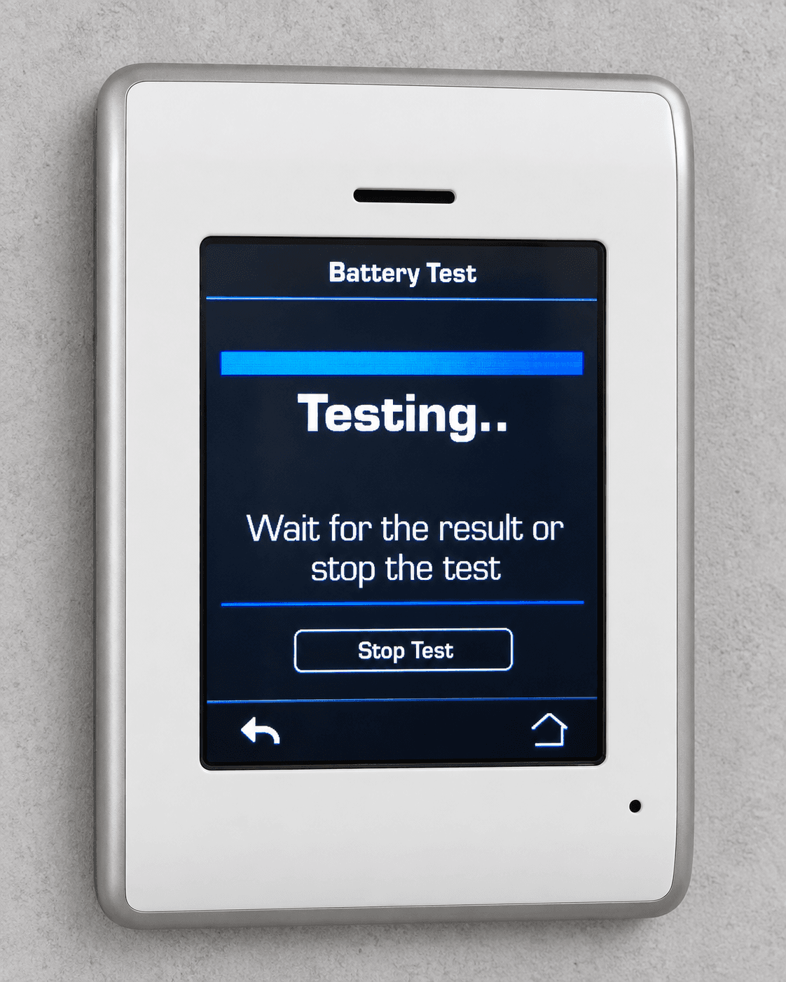 Wall-mounted control panel displaying a battery test in progress with a blue progress bar.